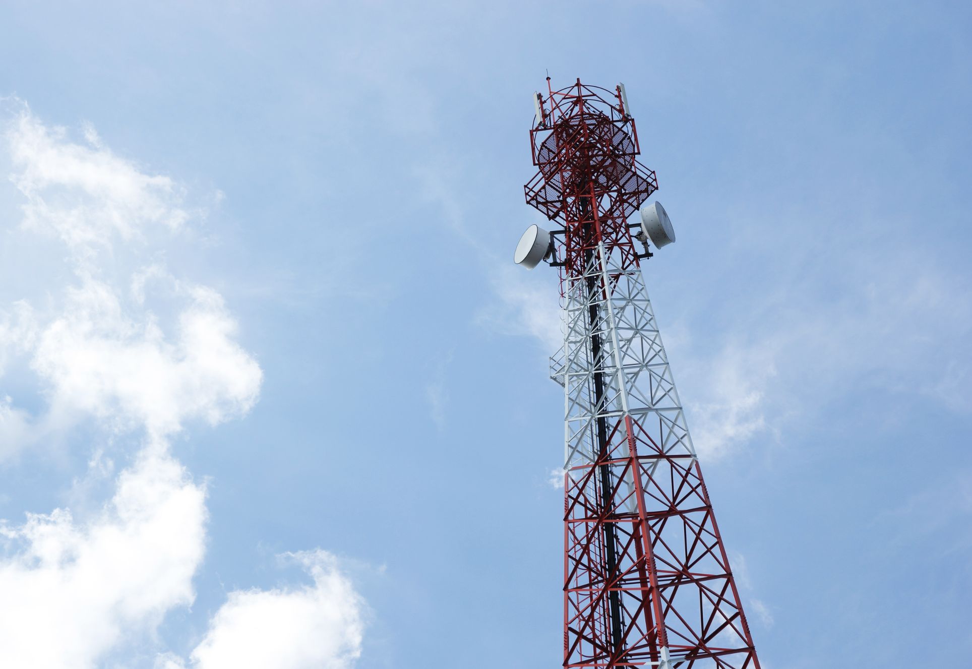 Telecommunications antenna radio television telephone with cloud blue sky